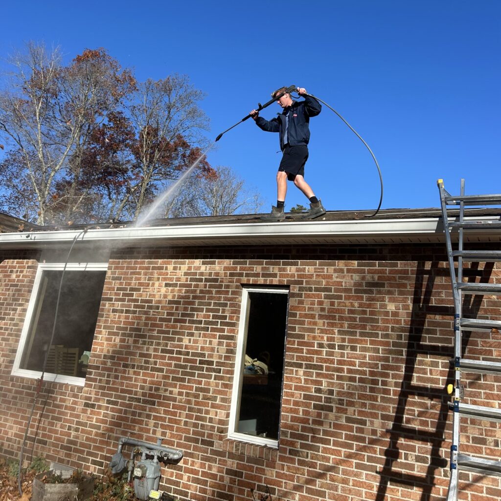 Worker soft washing house siding in Freehold, NJ